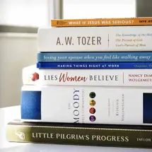 A stack of Christian books by Moody Publishers on a table
